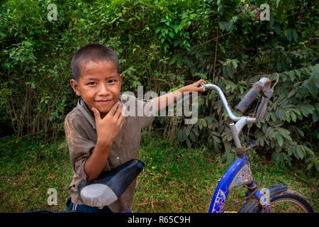 Junge lokale Junge mit einem Fahrrad in Vang Vieng Dorf, Laos Stockfoto