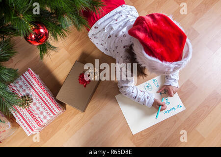 Kleine Mädchen die Vorbereitung der Santa schreiben Stockfoto