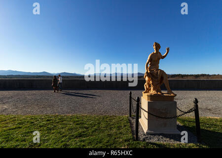 Ein paar Spaziergänge auf der Südterrasse mit Blick auf die Berge, eine Statue allein im Vordergrund, im Biltmore Estate in Asheville, NC, USA. Stockfoto