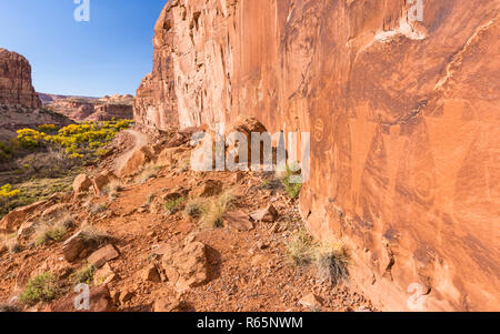 Felszeichnungen entlang Kane Creek Road über Kane Springs Canyon mit goldener Herbst Cottonwood Bäumen in der Nähe von Moab, Utah. Stockfoto