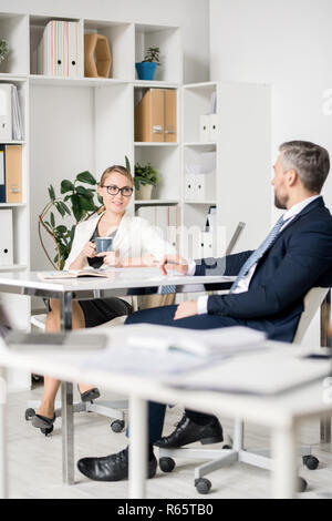 Attraktive Dame über die zukünftigen Pläne mit Kollegen Stockfoto