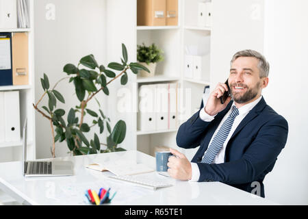 Fröhliche Geschäftsmann die Kommunikation über Mobiltelefon Stockfoto