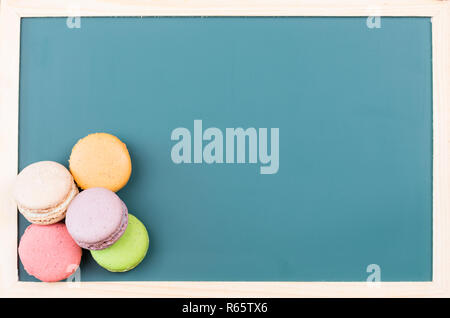 Macarons auf einer grünen Tafel Nahaufnahme Stockfoto
