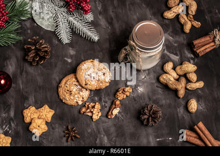 Weihnachten und neues Jahr feier Tischdekoration Hintergrund mit Girlande, Cookies, Tannenzapfen, wallnuts und Kerze in Schale Stockfoto