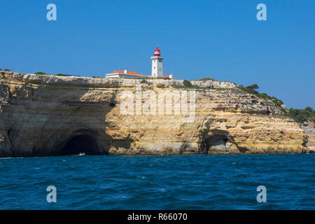 Eine Ansicht von Alfanzina Leuchtturm über die schroffe Kalkfelsen und Grotten entlang der Küste der Algarve in Portugal. Stockfoto