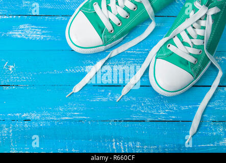 Grünen Sneakers auf einem blauen Hintergrund aus Holz Stockfoto