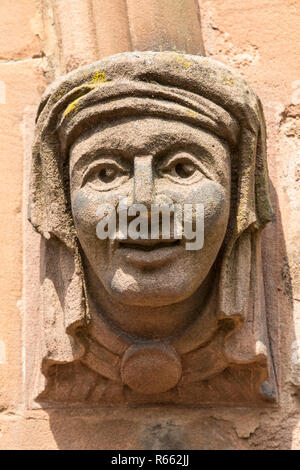 Eine kleine Skulptur an der Außenseite der historischen St. Johannes der Täufer Kirche in der Stadt Coventry in Großbritannien. Stockfoto