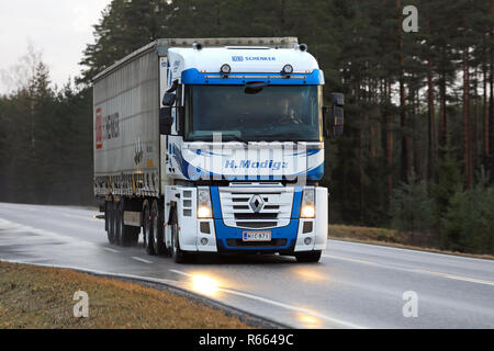 SALO, Finnland - 8. DEZEMBER 2017: Blau und Weiß Renault Magnum Lkw von Helmer Modig Oy zieht DB Schenker trailer entlang nasse Autobahn im frühen Winter. Stockfoto