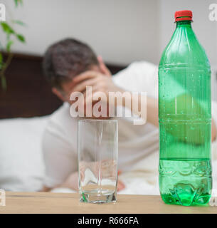 Mann trinken Wasser und Leiden von Kater. Stockfoto