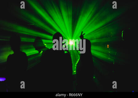 Weibliche und männliche Tänzer durch die Lichter in der Nacht Club. Stockfoto