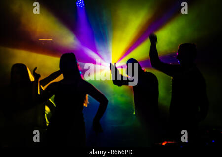 Weibliche und männliche Tänzer durch die Lichter in der Nacht Club. Stockfoto