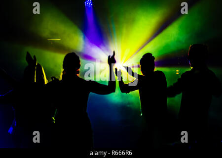 Weibliche und männliche Tänzer durch die Lichter in der Nacht Club. Stockfoto