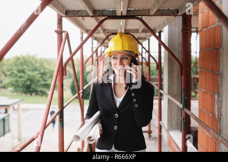 Ingenieurin Gespräch am Handy in Baustelle Stockfoto