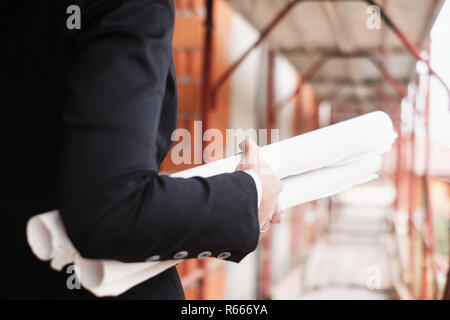 Frau arbeitet als Ingenieur Holding Baupläne Stockfoto