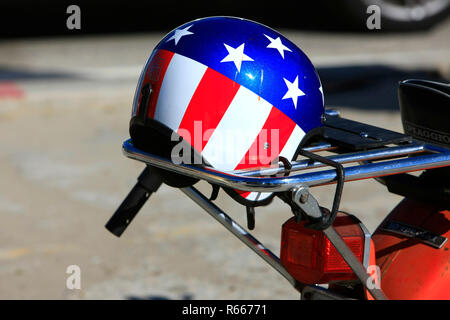 Patriotische Sternenbanner Sturzhelm ruht auf einem motorradhalter glitzert in der Sonne Kaliforniens Stockfoto