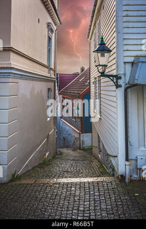 Engen kopfsteingepflasterten Gassen zwischen den alten traditionellen Häusern in Bergen. Stockfoto