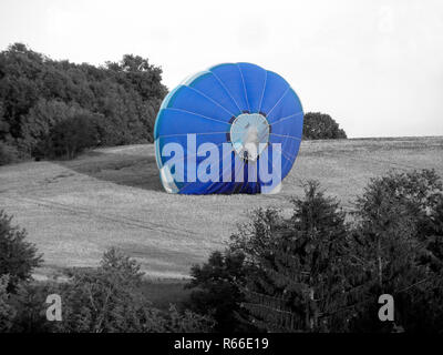 Blue Hot Air Balloon beginnt auf einem Weizenfeld - schwarz und weiß gefärbten Sammlung Stockfoto