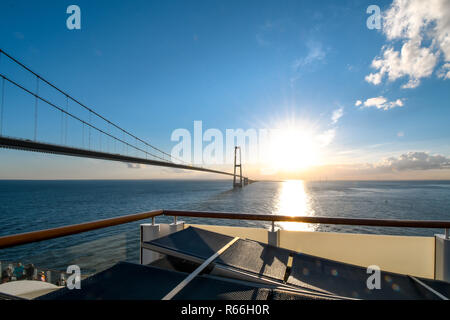 Blick auf die untergehende Sonne über den Öresund Brücke über die Meerenge zwischen Dänemark und Schweden von einem Boot auf der Ostsee. Stockfoto