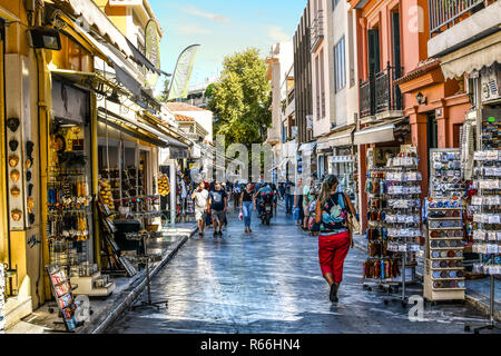 Touristen zu Fuß die Straßen mit Souvenirläden und Outdoor Cafes in der touristischen Plaka in Athen, Griechenland. Stockfoto