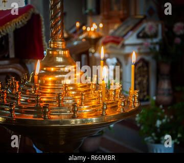 Brennende Kerzen auf einem Ständer in der Kirche Stockfoto