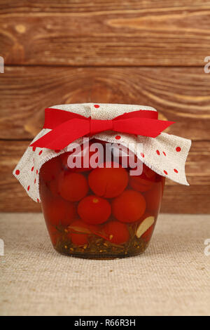 Jar eingelegte Kleine rote Kirschtomaten auf Tabelle Stockfoto