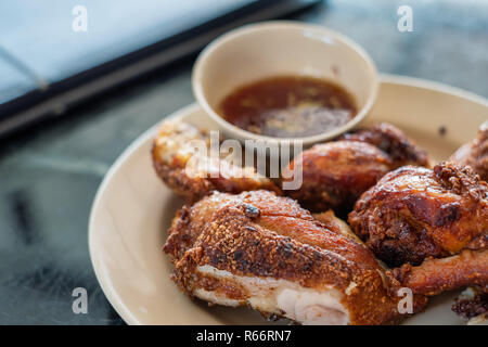 Gebratenes Huhn mit würzigen Quelle in Thai Menü Stil serviert bereit, gegessen zu werden. Stockfoto