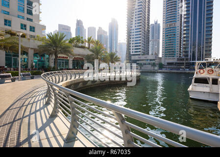 Dubai, Vereinigte Arabische Emirate - 25. Juli 2018: Ein Blick auf die Brücke und die Art und Weise an der Dubai Marina, mit verschiedenen Geschäften, Boote und Wolkenkratzer Stockfoto