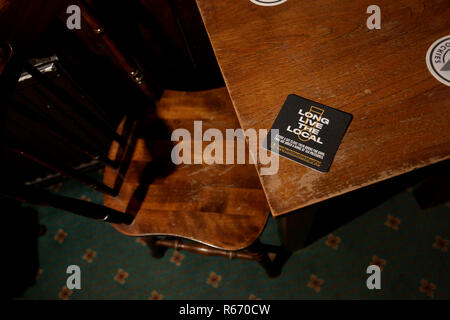 Beermat in einem kleinen Pub Förderung der lokalen Pub lesen "Lang lebe die Lokalen". Dargestellt in Chichester, West Sussex, UK. Stockfoto