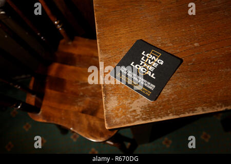 Beermat in einem kleinen Pub Förderung der lokalen Pub lesen "Lang lebe die Lokalen". Dargestellt in Chichester, West Sussex, UK. Stockfoto