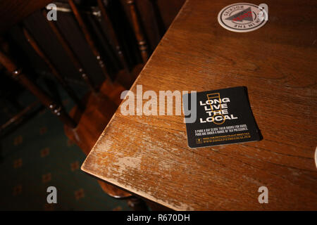 Beermat in einem kleinen Pub Förderung der lokalen Pub lesen "Lang lebe die Lokalen". Dargestellt in Chichester, West Sussex, UK. Stockfoto