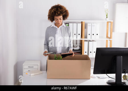 Geschäftsfrau packen Ihre Sachen in Kartons Stockfoto