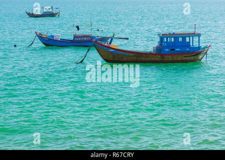 Vietnamesische Küste mit Blick auf das Südchinesische Meer in Nha Trang Vietnam mit einem türkisfarbenen Meer und Fischerboote. Stockfoto