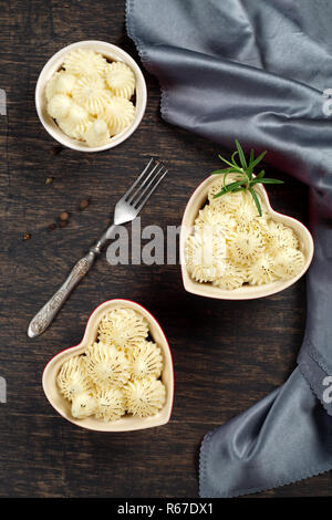 Shepherd's Pie in kleinen, individuellen Herzform rot ramikens, traditionelle britische Gerichte mit Hackfleisch und Kartoffelbrei auf rustikalen Holztisch, top v Stockfoto