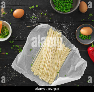 Zutaten zum Kochen vegetarische Udon-nudeln auf dunklen Holztisch in der Küche zu Hause Top View Stockfoto