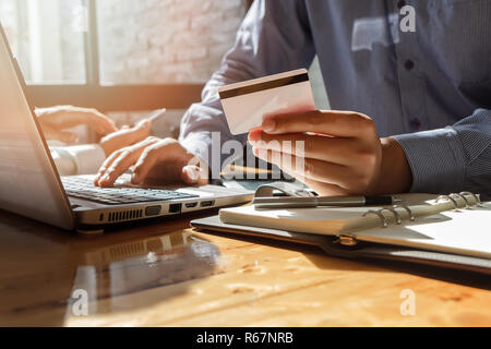 Unternehmer, die Kreditkarte und mit Laptop. Die Zahlung beim Online shopping. E-Commerce und moderne Technik Konzept Stockfoto