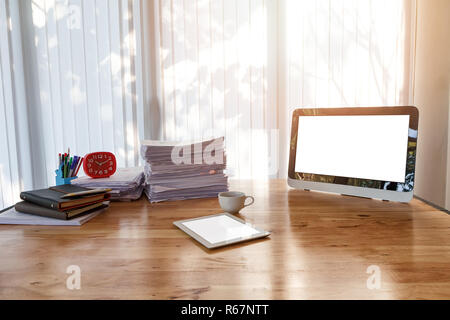 Monitor- und Bürobedarf auf Büro Schreibtisch. Holztisch mit Büromaterial im Home Office am Morgen Stockfoto