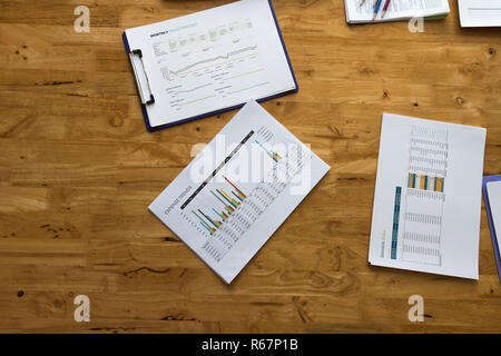 Blick von oben auf die wirtschaftszeitung Tabelle oder Grafik auf hölzernen Tisch Stockfoto