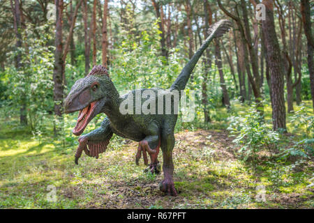 Lebensgröße Raptor Dinosaurier Statue in einem Wald Stockfoto