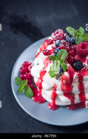 Pavlova mit Vanillesauce und frisches Obst an der Platte. Stockfoto