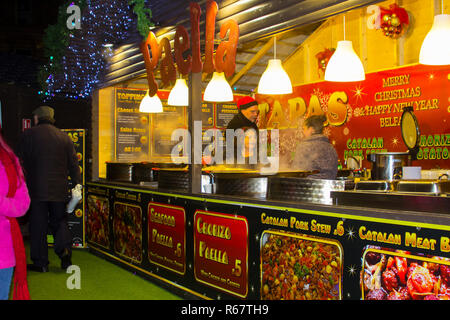 30. November 2018 einem langen garküche verkaufen spanische Gerichte im Belfast Weihnachtsmarkt in einem hölzernen Stand auf dem Gelände der Belfast City Hall entfernt. Stockfoto