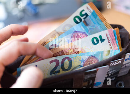 Dresden, Deutschland. 04 Dez, 2018. Abbildung - eine Frau hält eine Mappe mit zahlreichen Banknoten und Karten in Ihrer Hand (inszenierte Szene). Credit: Monika Skolimowska/dpa-Zentralbild/ZB/dpa/Alamy leben Nachrichten Stockfoto