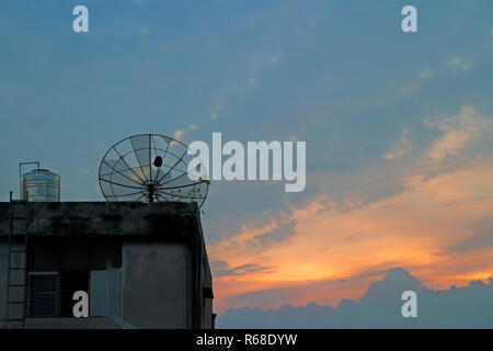 Sat-alte Schüssel auf dem Dach am Abend Stockfoto