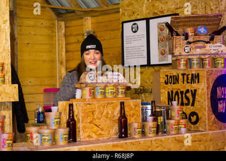 30. November 2018 Eine junge Frauen Anbieter verkaufen Muttern iat die Belfast Weihnachtsmarkt in Nordirland. Die Messe ist mittlerweile eine beliebte jährliche Veranstaltung in der c Stockfoto