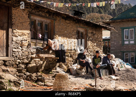 Nepal, Lukla, Menschen saßen außerhalb der traditionellen, aus Stein gebauten Haus in der Mitte des Dorfes Stockfoto