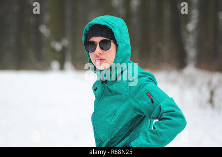 Portrait einer weiblichen Radfahrer Athlet in Sonnenbrille im Winter Forest. Radfahrer auf Cyclocross Bike Trails in den verschneiten Wald im Winter. Winter worko Stockfoto