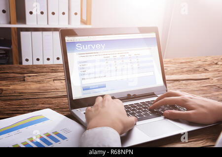 Unternehmer füllen Online Umfrage Formular auf Laptop Stockfoto