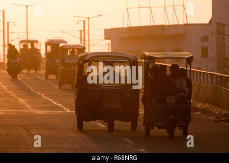 Auto-rikschas und Verkehr auf Überführung bei Sonnenuntergang in Jaipur, Rajasthan, Indien Stockfoto