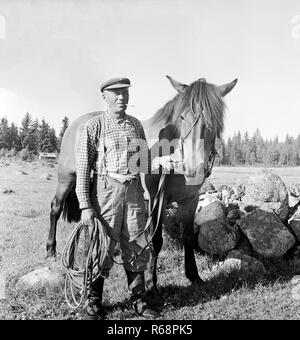 Porträt der Mann hält Zügel der kleine Pferd in Landschaft Landwirtschaft, Finnland 1959 Stockfoto