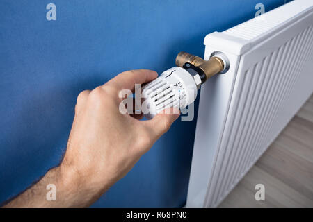 Hand Einstellen der Temperatur am Thermostat Stockfoto