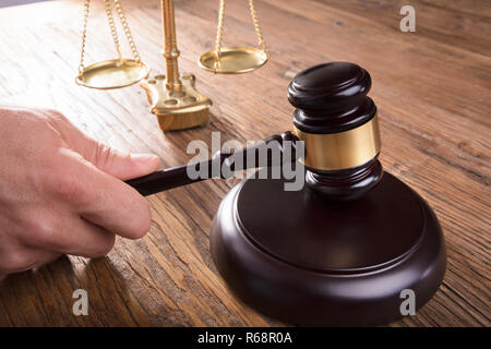 Richter schlagen Hammer der Gerechtigkeit Maßstab auf hölzernen Tisch Stockfoto